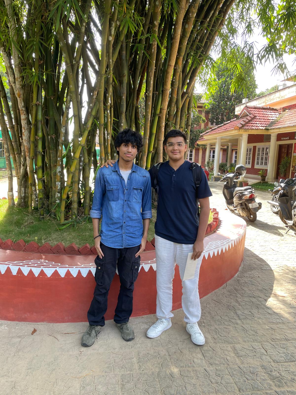 Aveer and a fellow intern standing in front of bamboo at the research centre campus
